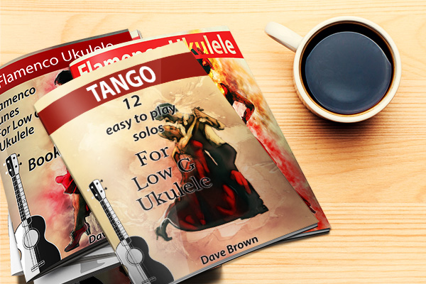 pile of ukulele books on desktop with cup of coffee